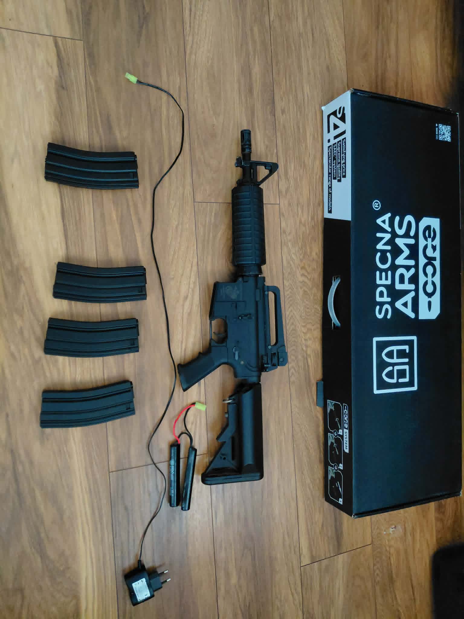 Zestaw replika Specna Arms SA-CO2, z 4 magazynkami, ładowarką i baterią.